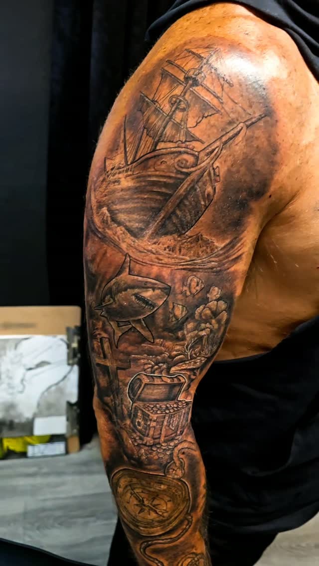 Tattoo by Angel at Z-Edge Gulf Gate: black and grey nautical sleeve with a pirate ship and shark