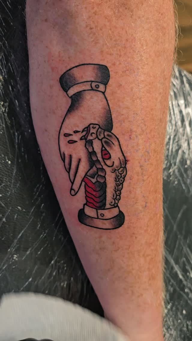 Tattoo by Angel at Z-Edge Gulf Gate: traditional hand and snake in black and red