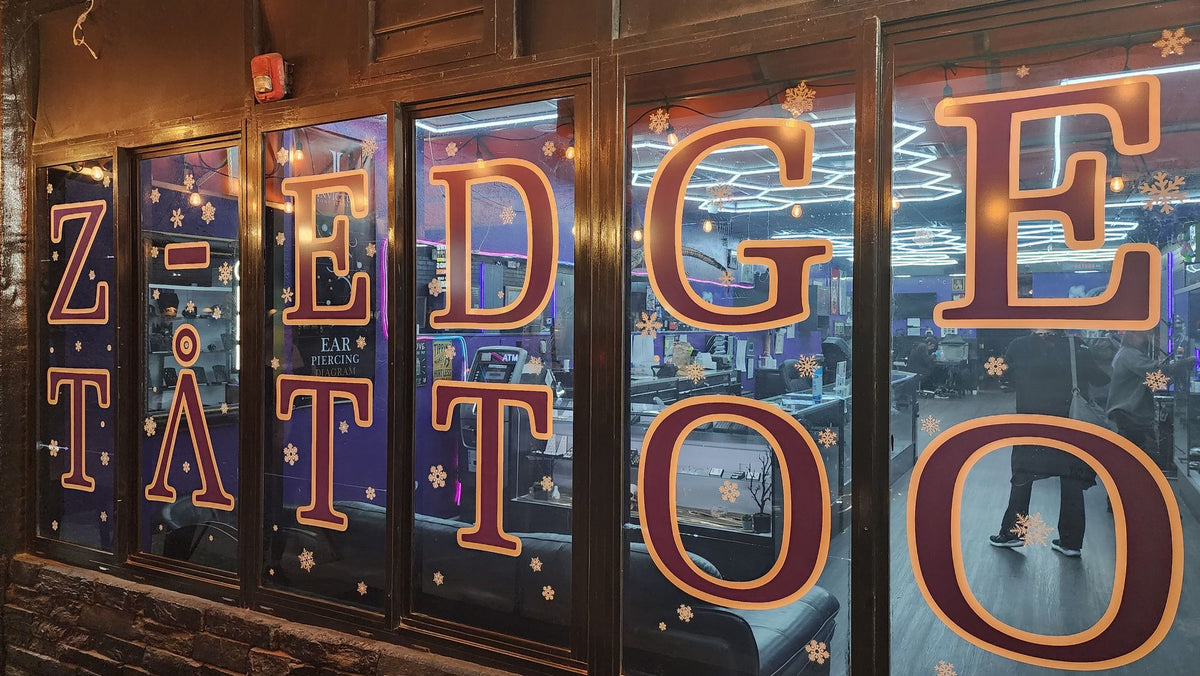 The lit Z-Edge Tattoo sign in the Gulf Gate window